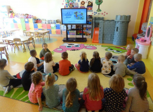 Grupa dzieci ogląda prezentację multimedialną na temat higieny.